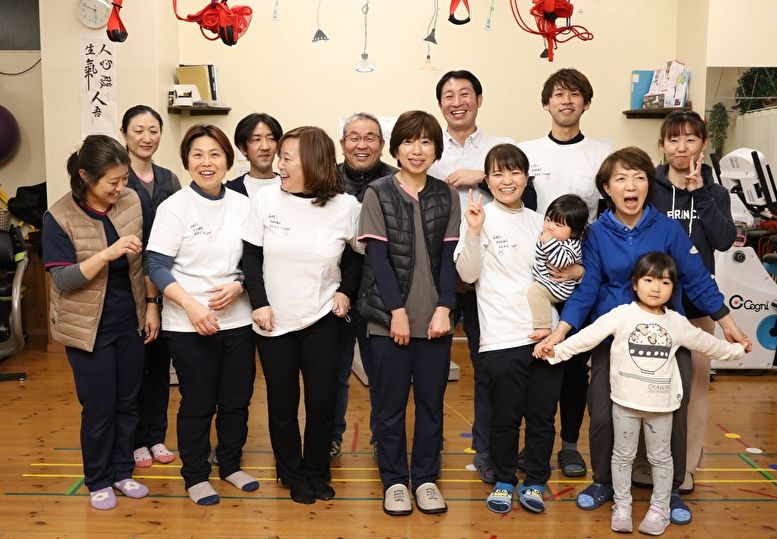 施設の中で並んで笑顔を見せるスタッフと子どもたち